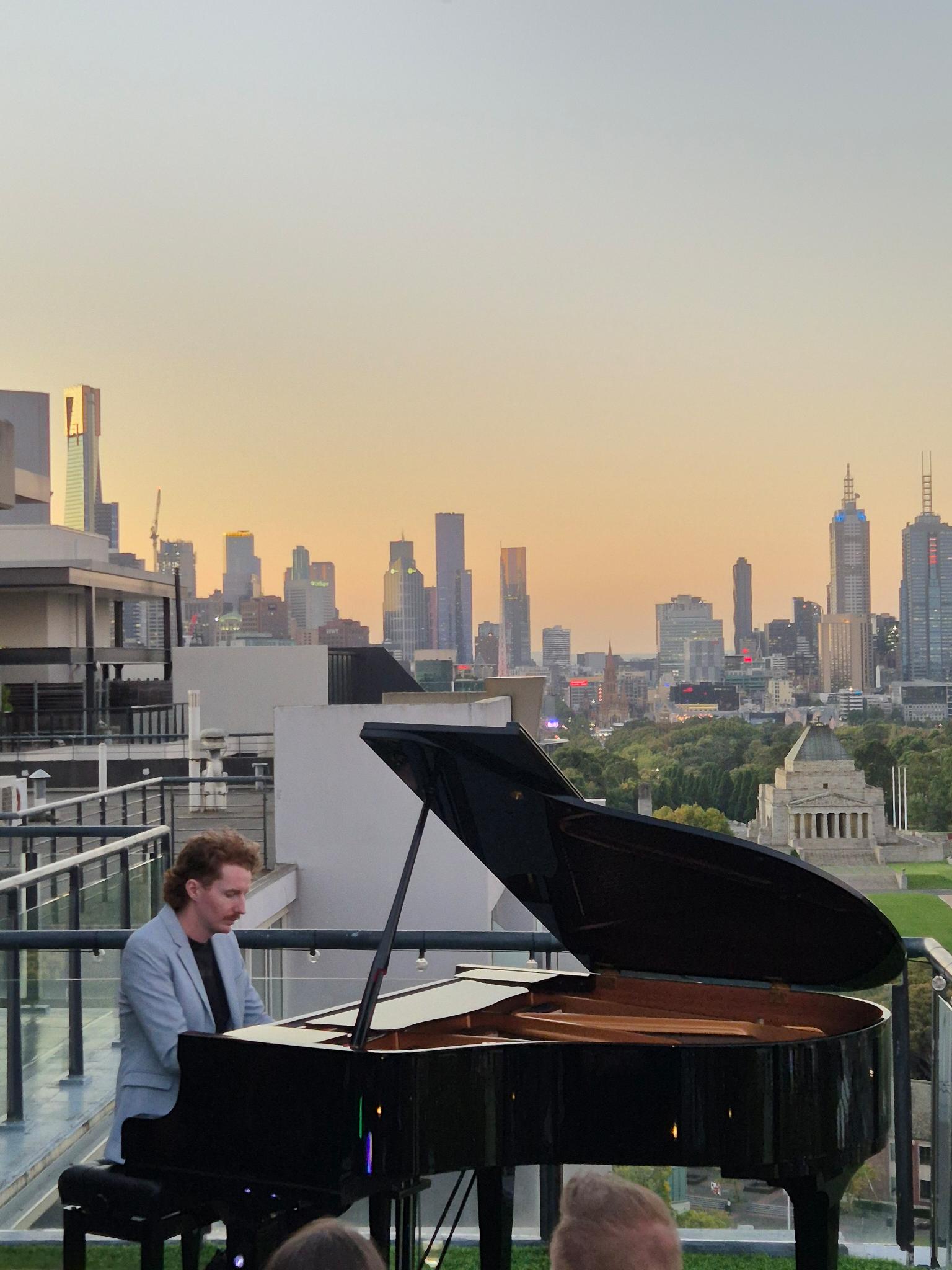 Harry playing piano with Melbourne skyline